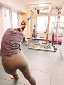 A client practicing posture correction and mobility training in a private gym in Shinjuku, Tokyo.